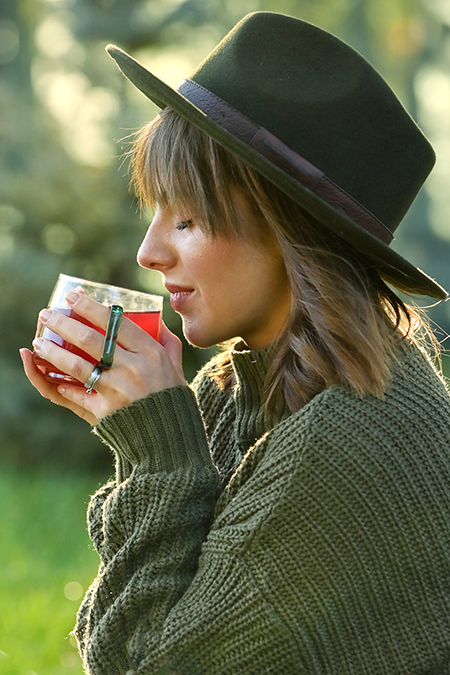 A quiet morning ritual in soft light: stretching by an open window, tea in hand, unhurried